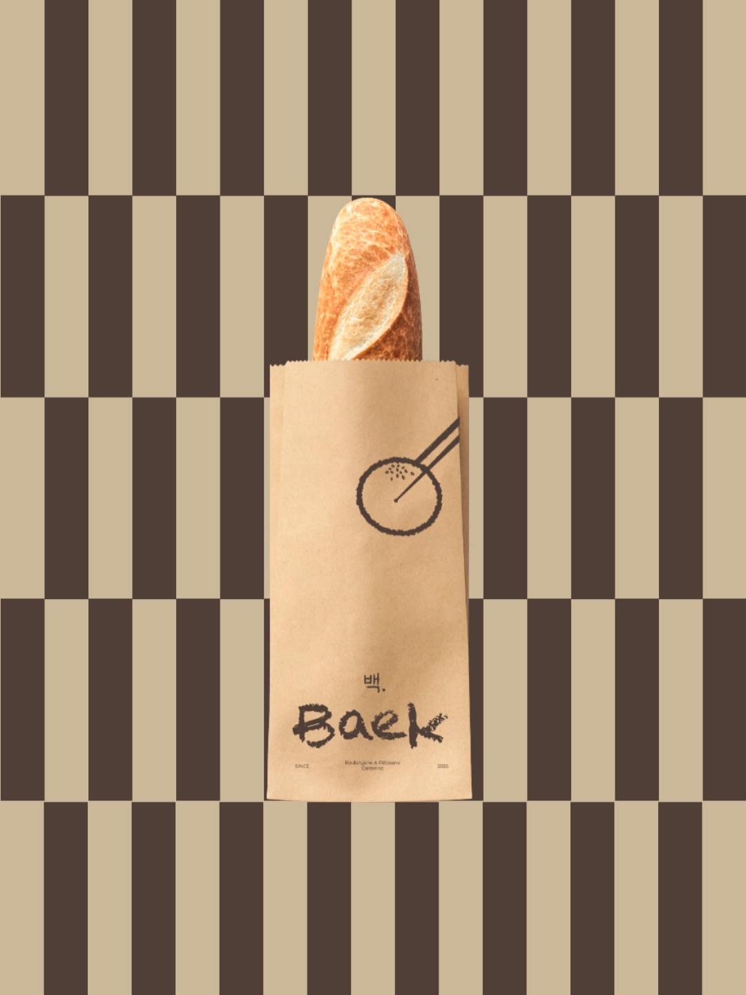 Une baguette dans un sac kraft imprimé du pictogramme Baek, sur fond de damier brun.